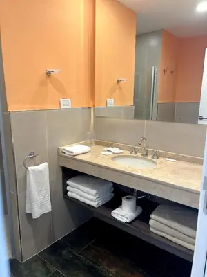 a bathroom with a sink and a mirror and towels at Gran Hotel Cosquin in Cosquín