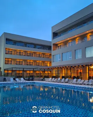 a hotel with a swimming pool in front of a building at Gran Hotel Cosquin in Cosquín