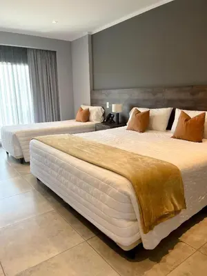 a hotel room with two beds in a room at Gran Hotel Cosquin in Cosquín