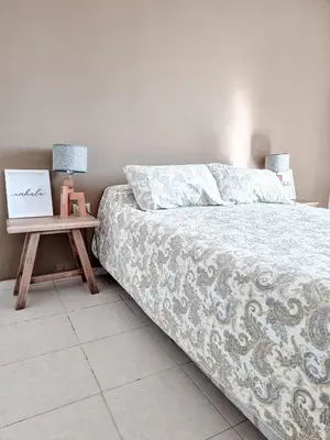 a bedroom with a bed and a table with a picture at Dpto ob trejo - pileta asador quincho vista a las sierras in Cordoba