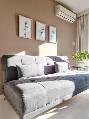 a large couch in a living room with paintings on the wall at Dpto ob trejo - pileta asador quincho vista a las sierras in Cordoba