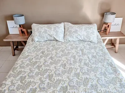 a bed with two nightstands and two lamps at Dpto ob trejo - pileta asador quincho vista a las sierras in Cordoba