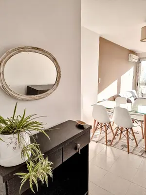 a living room with a mirror and a table and chairs at Dpto ob trejo - pileta asador quincho vista a las sierras in Cordoba