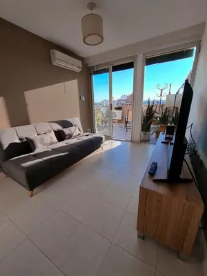 a living room with a couch and a flat screen tv at Dpto ob trejo - pileta asador quincho vista a las sierras in Cordoba