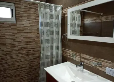 a bathroom with a sink and a shower with a mirror at cabañas sunrise in Merlo