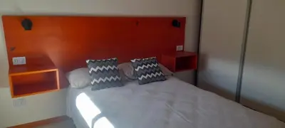 a bedroom with a large bed with two pillows at cabañas sunrise in Merlo