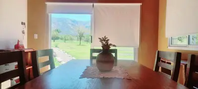 a vase sitting on a table in front of a window at cabañas sunrise in Merlo