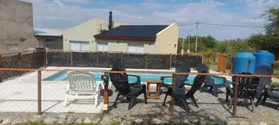 a group of chairs sitting next to a swimming pool at cabañas sunrise in Merlo