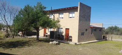 a house with a tree in front of it at cabañas sunrise in Merlo