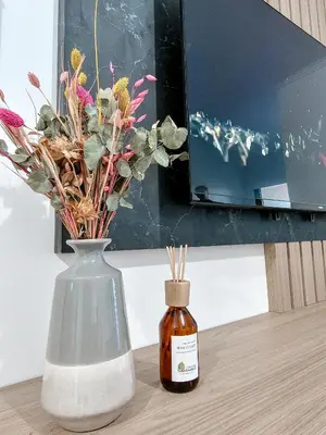 a bottle of honey next to a vase with flowers at Dpto Poeta lugones 72 - pileta terraza parrilla in Cordoba