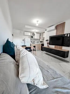 a living room with a couch and a television at Dpto Poeta lugones 72 - pileta terraza parrilla in Cordoba
