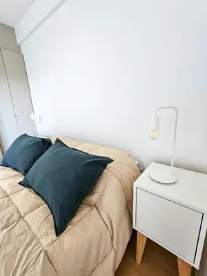 a bedroom with a bed and a white night stand at Dpto Poeta lugones 72 - pileta terraza parrilla in Cordoba