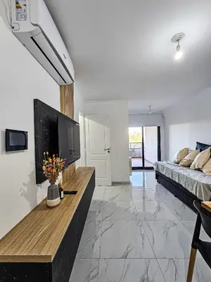 a living room with a bed and a tv in it at Dpto Poeta lugones 72 - pileta terraza parrilla in Cordoba
