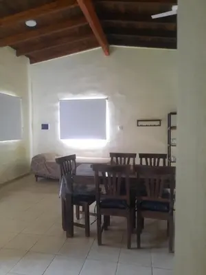a dining room with a table and chairs and a couch at Cabaña La Kalma in Santa María