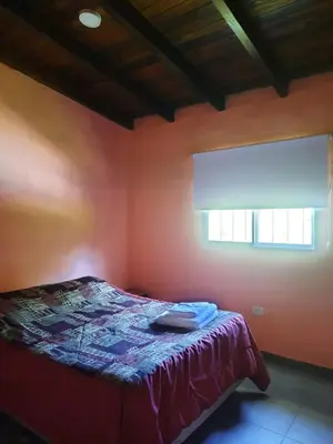a bedroom with a bed in a room with a window at Cabaña La Kalma in Santa María