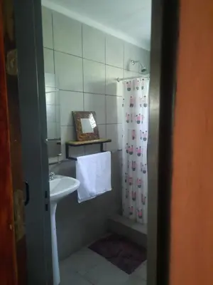 a bathroom with a sink and a shower curtain at Cabaña La Kalma in Santa María