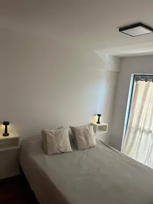 a bedroom with a bed with two pillows and a window at Pueyrredón 76 in Cordoba