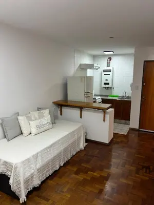 a bedroom with a large bed and a kitchen at Pueyrredón 76 in Cordoba