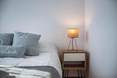 a bedroom with a bed with a lamp on a night stand at Cómodo Departamento en Pleno Centro in Cordoba