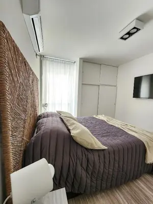 a bedroom with a bed with a purple comforter at Dpto Ituzaingo 1270 - 2 dormitorios in Cordoba