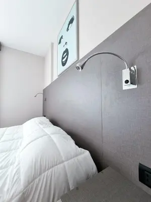 a bedroom with a white bed and a lamp at Dpto ituzaingo 741 - 1 dormitorio in Cordoba