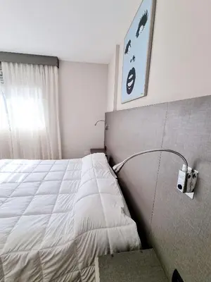 a bedroom with a bed with a light on the wall at Dpto ituzaingo 741 - 1 dormitorio in Cordoba