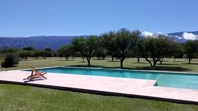 a swimming pool with a chair in the grass at Las icarias in Las Calles