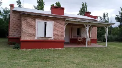 a red brick house with a white window and a patio at Las icarias in Las Calles