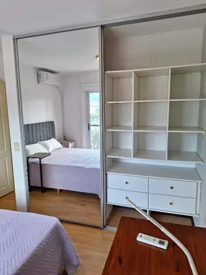 a bedroom with a mirrored closet and a bed at Departamento en Torre Serena in Villa Carlos Paz