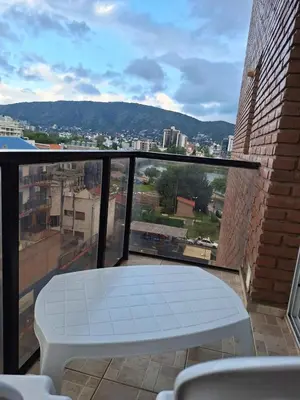 a balcony with a table and a view of a city at Departamento en Torre Serena in Villa Carlos Paz