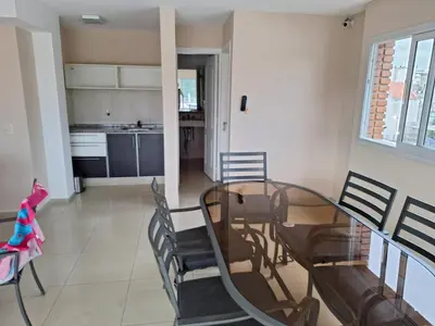 a dining room with a glass table and chairs at Departamento en Torre Serena in Villa Carlos Paz