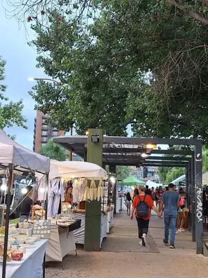 a group of people walking through an outdoor market at Departamento en Torre Serena in Villa Carlos Paz