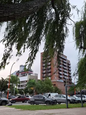 a parking lot with cars parked in front of a building at Departamento en Torre Serena in Villa Carlos Paz