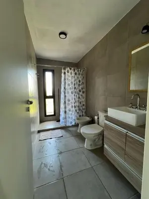 a bathroom with a toilet and a sink and a tub at El Paisaje in Villa Parque Siquiman
