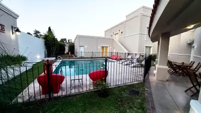 a black fence with a pool in a yard at Laplace Hotel in Cordoba