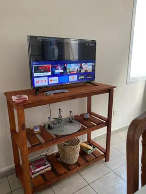 a television on top of a wooden table at Blu Trino Departamento a metros de Barrio Güemes in Cordoba