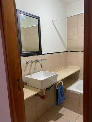 a bathroom with a sink and a mirror and a toilet at Blu Trino Departamento a metros de Barrio Güemes in Cordoba