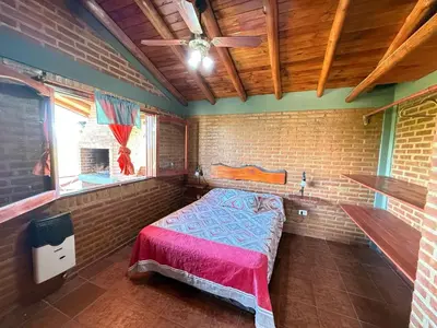a small room with a bed in a brick wall at Vista al río 2 dormitorios in Arroyo de Los Patos