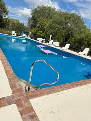a swimming pool with a hose in the water at Vista al río 2 dormitorios in Arroyo de Los Patos