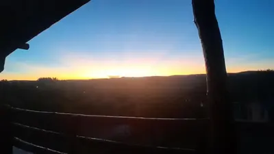 a view of the sunset through a window at Vista al río 2 dormitorios in Arroyo de Los Patos