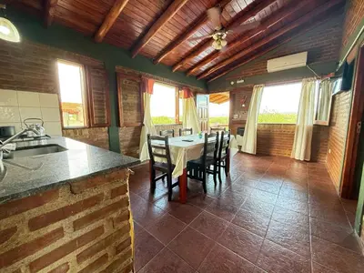 a kitchen with a table and chairs in a room at Vista al río 2 dormitorios in Arroyo de Los Patos