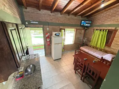 a kitchen and living room with a refrigerator and a table at Vista al río 2 dormitorios in Arroyo de Los Patos
