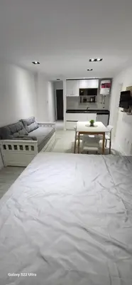 a living room with a large bed and a table at Miralejos 16 Apartamento in Villa Carlos Paz