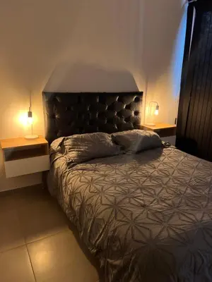 a bed in a bedroom with two lamps on tables at Alta Córdoba Nook in Cordoba