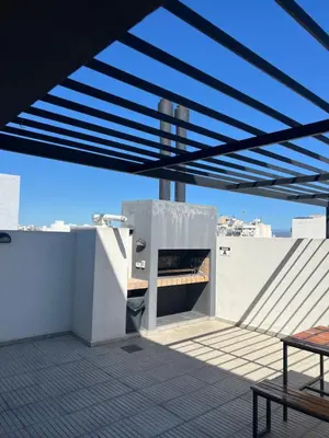a building with a roof with awning and a table at Alta Córdoba Nook in Cordoba