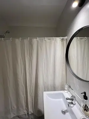 a bathroom with a shower curtain and a sink at Alta Córdoba Nook in Cordoba