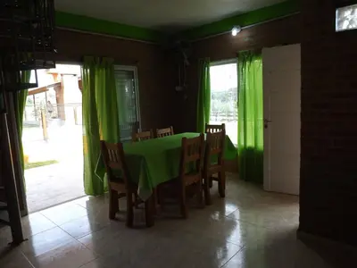 a dining room with a green table and chairs at Cabañas San Jose in Potrero de Garay
