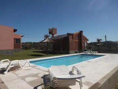 a swimming pool with two chairs and a chaise lounge at Cabañas San Jose in Potrero de Garay