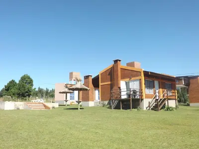 a brick house with a lawn in front of it at Cabañas San Jose in Potrero de Garay