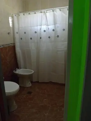 a bathroom with a white shower curtain and a toilet at Cabañas San Jose in Potrero de Garay